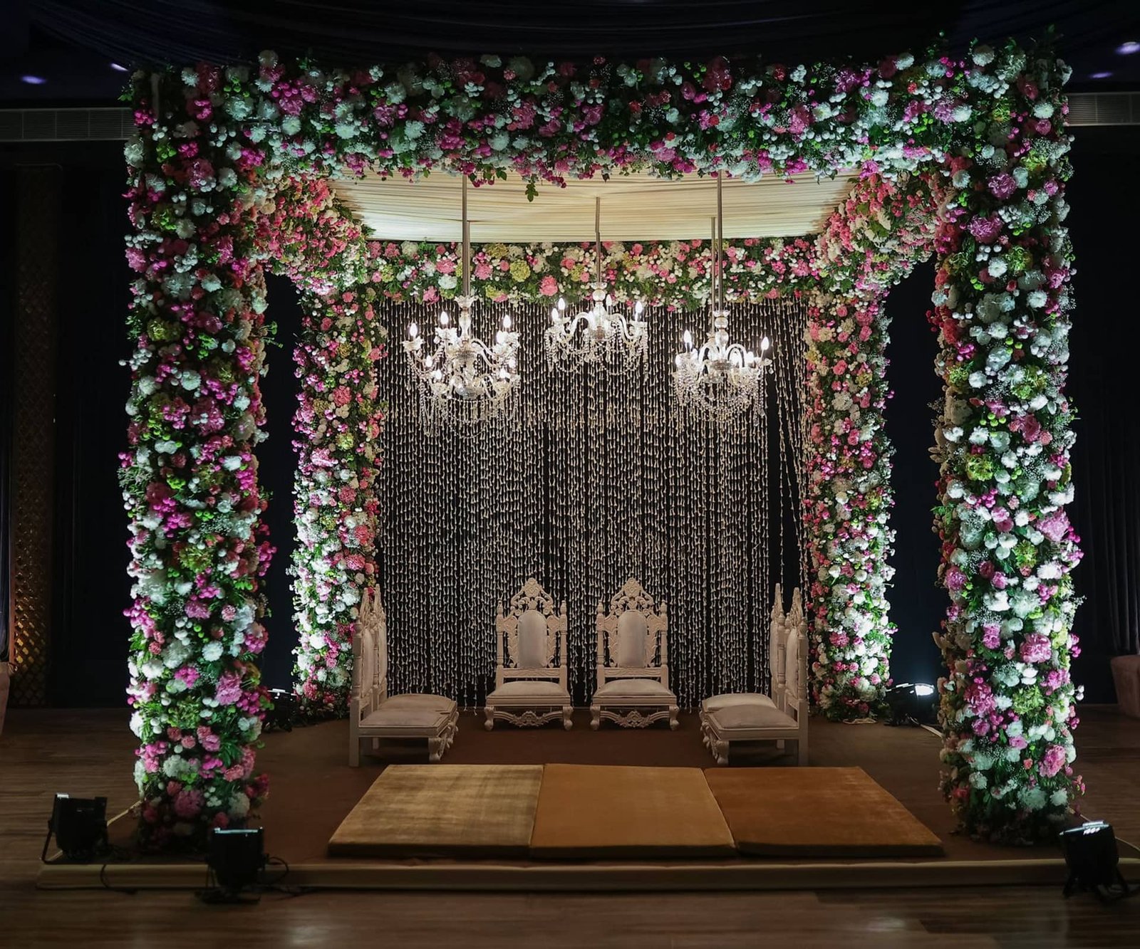 Wedding mandap lit up in gold at night